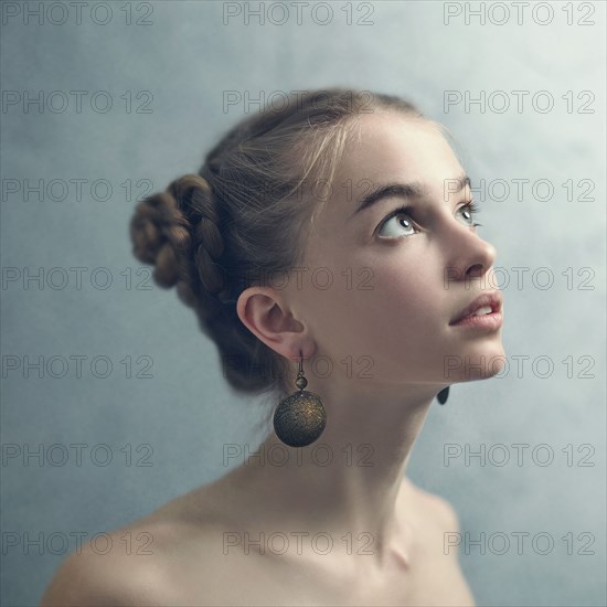 Teenage girl with braided hair wearing dangling earrings