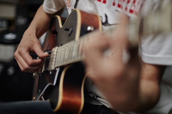 Close up of Caucasian man playing guitar