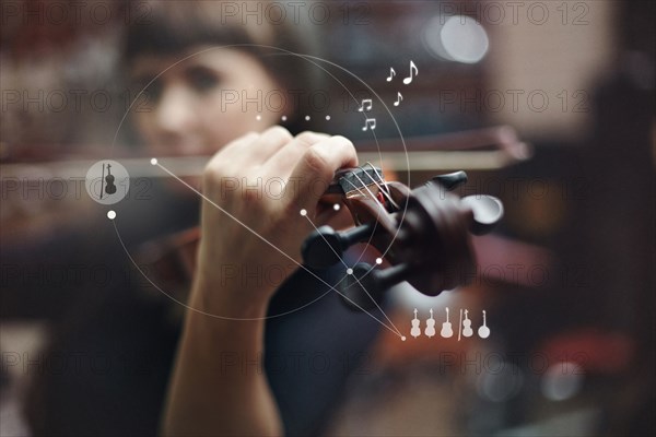 Caucasian woman playing violin overlaid with graphic design