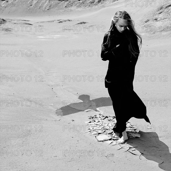 Caucasian teenage girl standing on beach near shadow of eagle