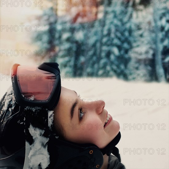 Caucasian snowboarder wearing goggles and helmet looking up