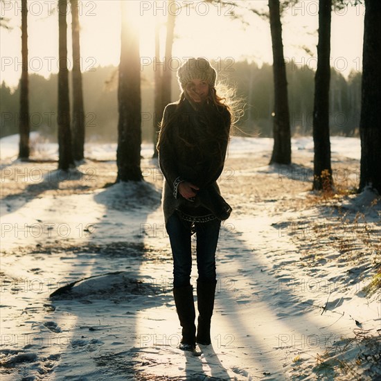 Caucasian woman standing in snowy forest