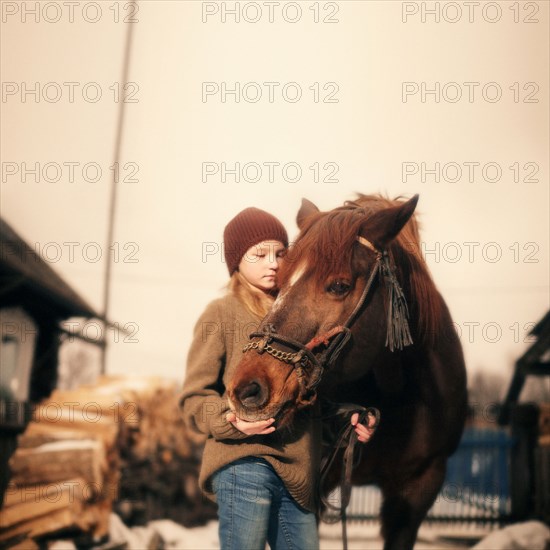 Caucasian girl holding rein of horse