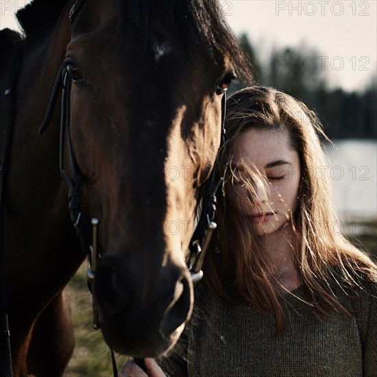 Caucasian woman walking with horse in field