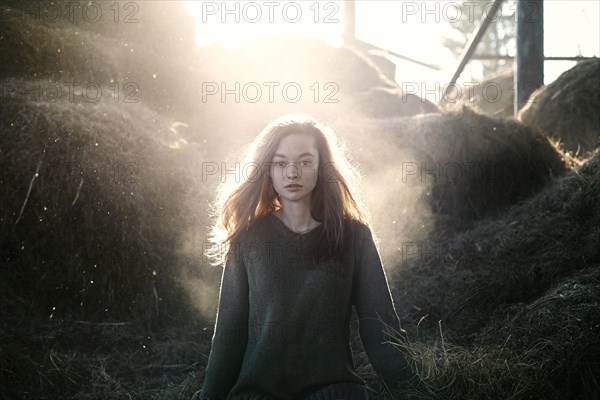 Caucasian woman walking standing near hay bales on farm