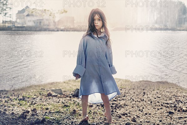 Caucasian girl standing at rural lake