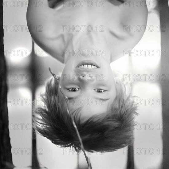 Caucasian boy hanging upside-down