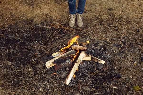 Caucasian teenage girl standing at campfire