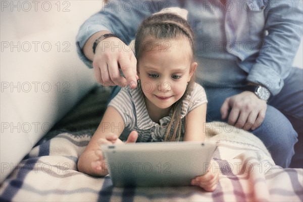 Caucasian father and daughter using digital tablet
