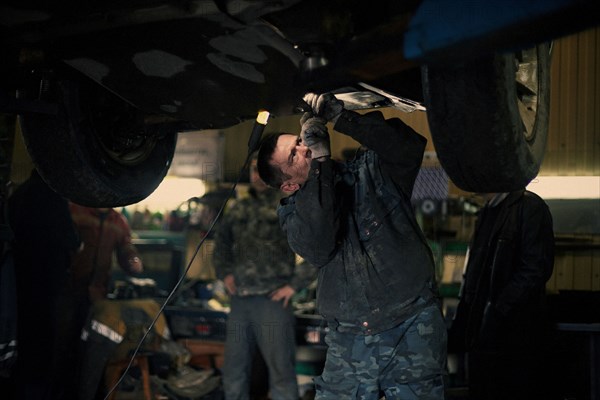 Caucasian mechanic fixing car