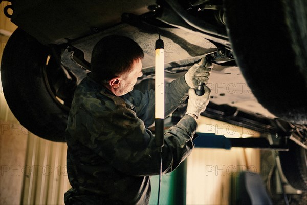 Caucasian mechanic fixing car