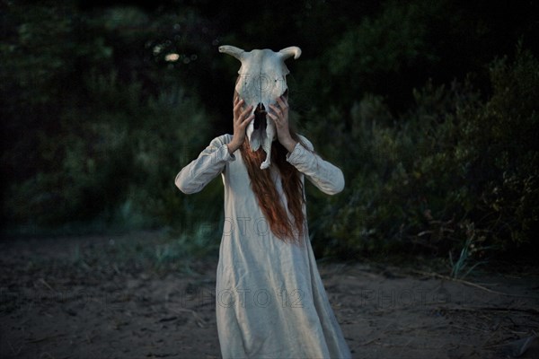 Caucasian woman wearing animal skull