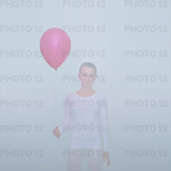Caucasian teenage girl holding balloon