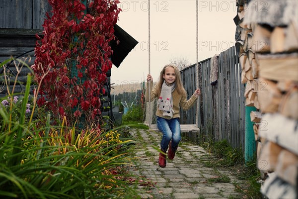 Caucasian girl playing on swing