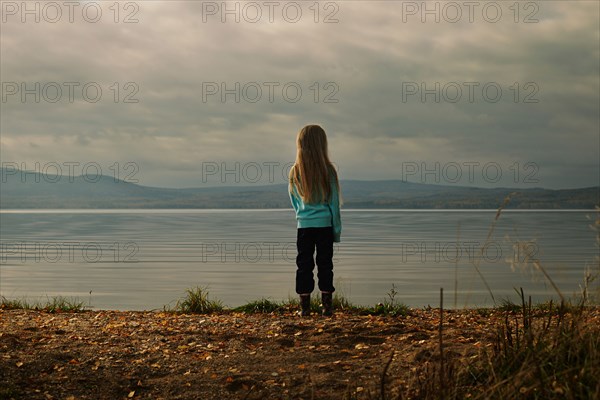Caucasian girl standing at lake