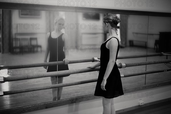 Caucasian ballerina standing at barre