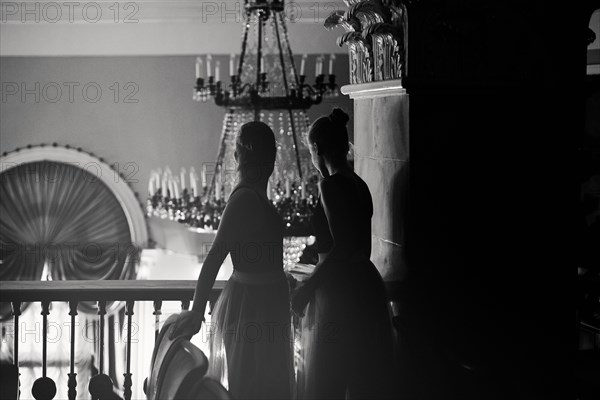 Caucasian teenage girls looking over balcony