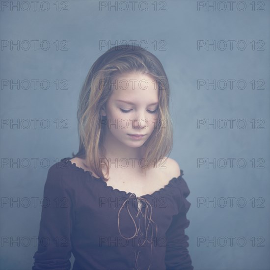 Caucasian teenage girl looking down