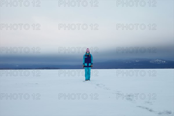 Caucasian teenage girl walking in snow