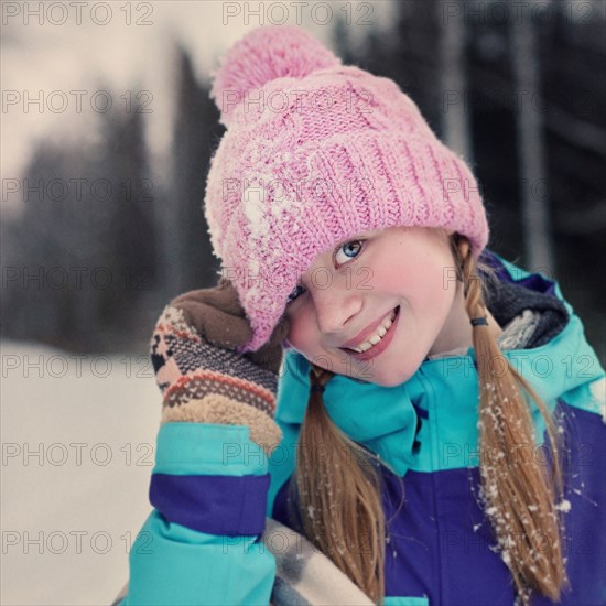 Caucasian teenage girl wearing beanie hat in snow