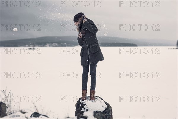 Caucasian teenage girl dodging snowballs