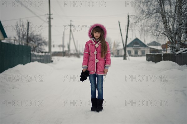 Caucasian girl standing on snowy street