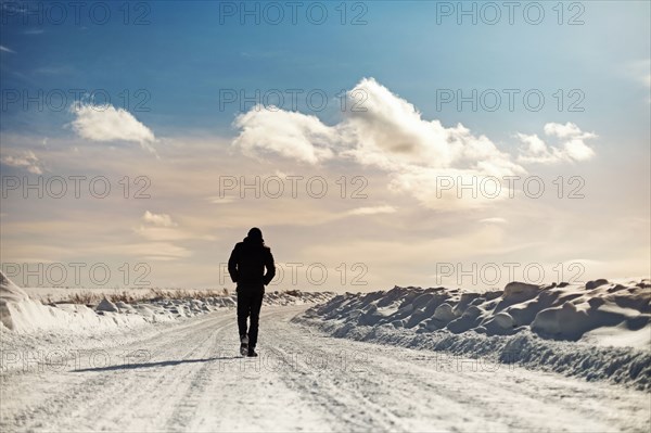 Caucasian man walking in snowy landscape