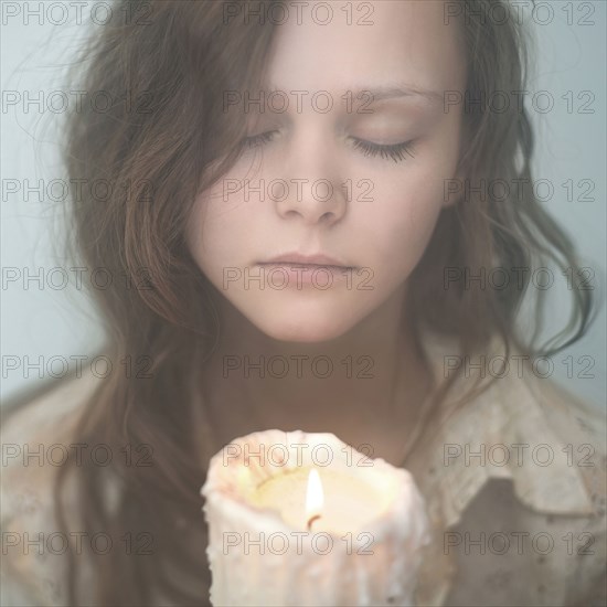 Caucasian woman holding melting candle