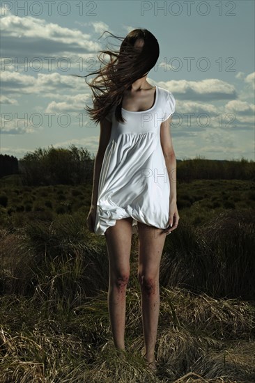 Caucasian woman standing in windy field