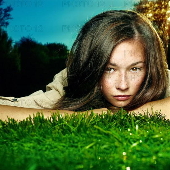 Caucasian teenage girl laying in grass