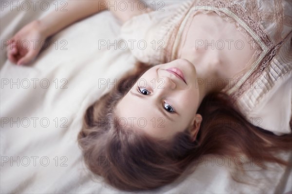 Caucasian teenage girl laying on bed