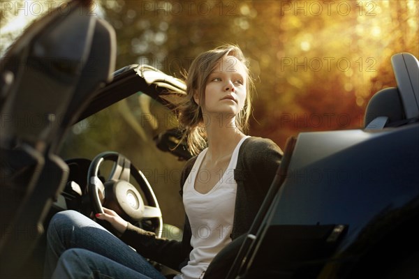 Caucasian teenage girl sitting in convertible