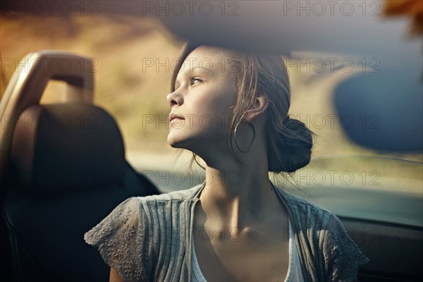 Caucasian teenage girl sitting in convertible