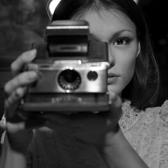 Caucasian teenage girl photographing with instant camera