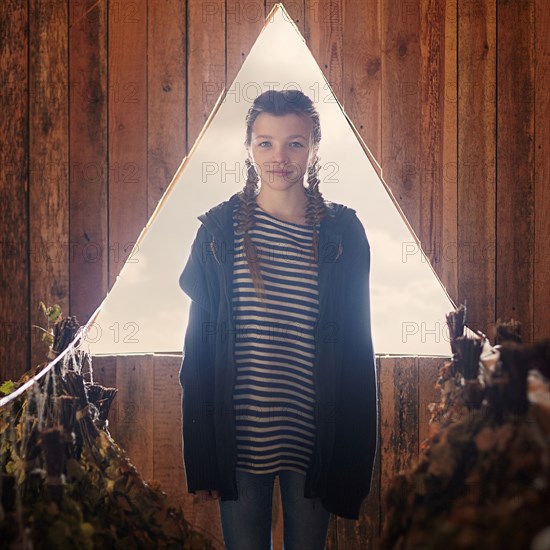 Caucasian teenage girl standing at window