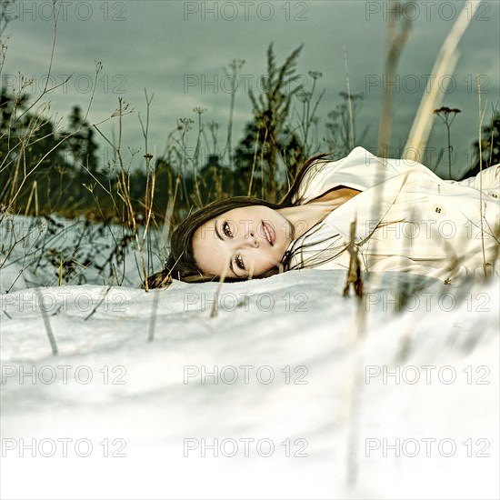 Caucasian woman laying in snow