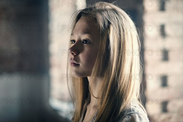 Caucasian girl standing at window