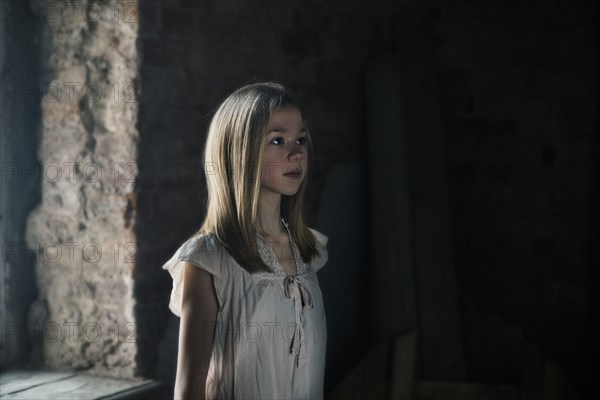 Caucasian girl standing at window