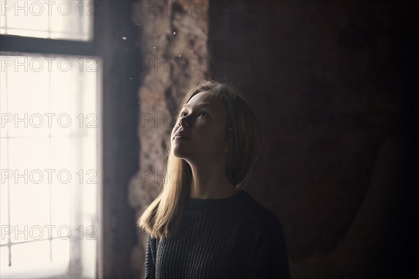 Caucasian girl standing at window