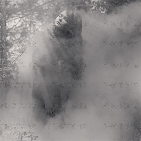 Caucasian woman standing in mist