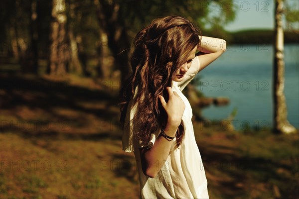 Caucasian woman standing near rural lake