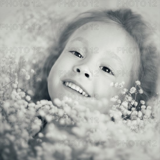 Caucasian girl laying in flowers