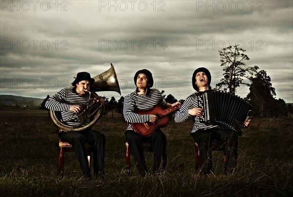 Caucasian band playing instruments in field