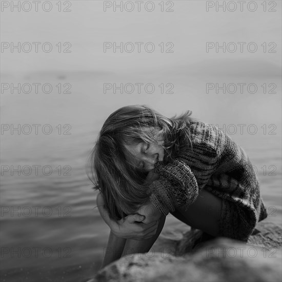 Caucasian girl sitting at remote river