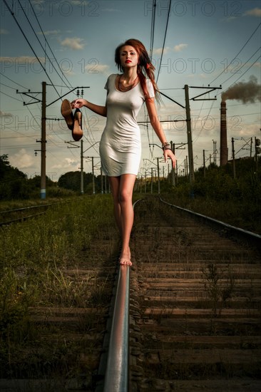 Caucasian woman balancing on train tracks