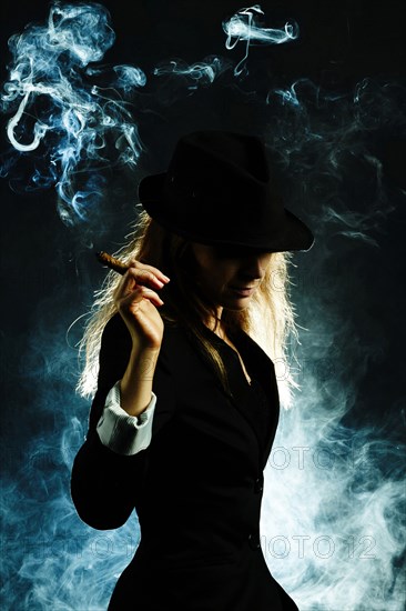 Silhouette of Caucasian woman smoking cigar