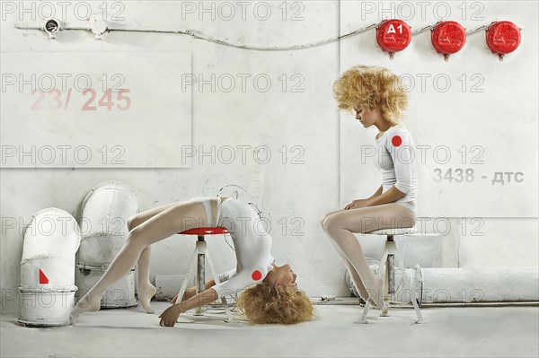 Double exposure of Caucasian dancer posing on stool