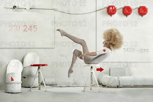 Caucasian dancer posing on stool