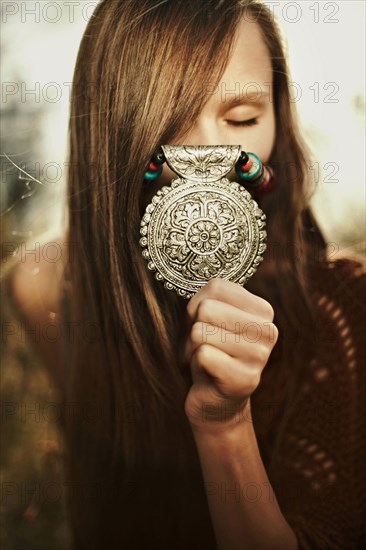 Close up of Caucasian woman showing medallion