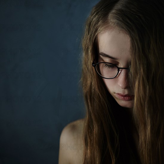 Caucasian teenage girl looking down